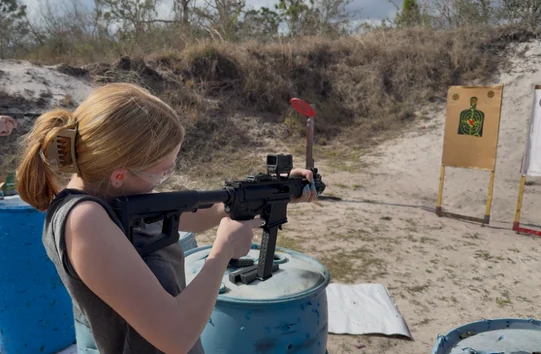 A first-time shooter on the line under supervision at an outdoor range in Okeechobee