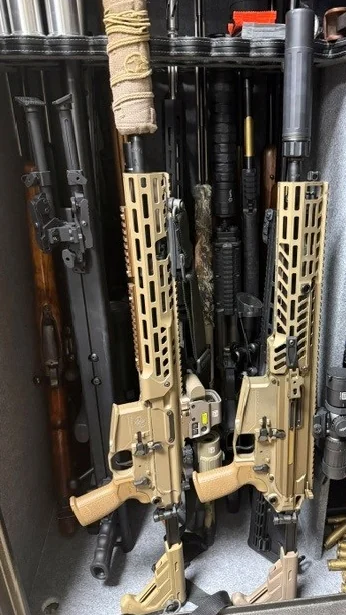 Rifles fitted with optics in the safe at Burnt Offerings Defense